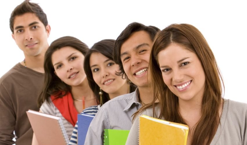 Group of students lined up holding notebooks isolated on a white background